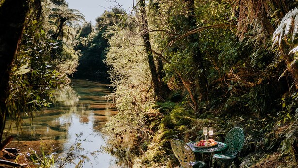 Un entorno tranquilo junto al río, con una mesa y sillas para comer al aire libre.