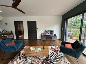 A spacious living area with a large TV, a wooden coffee table, and two sofas. - My Country House (EUGENIE LES BAINS)