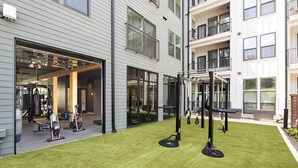 Une salle de sport équipée de matériel d’exercice et une vue de l’extérieur du bâtiment.