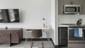 A modern kitchen with a microwave, oven, and a TV mounted on the wall. - Landing | Chic 1BD - One Bedroom Apartment, Sleeps 2 (Nashville)