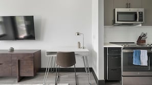 Eine moderne Küche mit Mikrowelle, Backofen und einem an der Wand befestigten Fernseher.