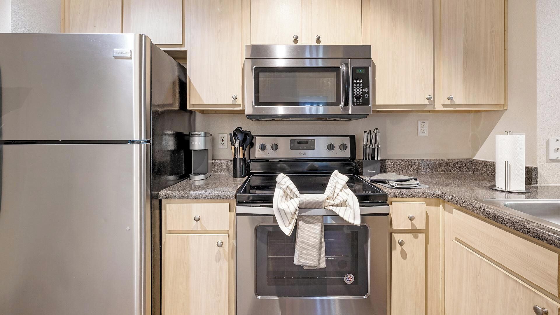 Eine Küche mit Edelstahlgeräten, darunter ein Kühlschrank, eine Mikrowelle und ein Backofen.