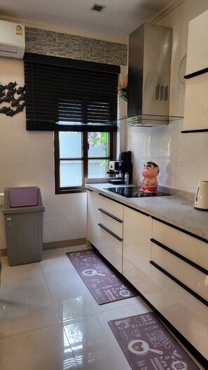 A kitchen with a coffee machine, a trash bin, and a decorative fish wall art. - Luxury 3-bedroom villa with private pool in Pattaya (Muang Pattaya)