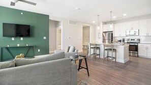 Ein modernes Apartment mit Wohnzimmer, Küche und Essbereich.
