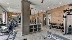Un gimnasio con cintas de correr, máquinas de pesas y mancuernas.