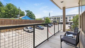 Ein Balkon mit Blick auf einen Parkplatz und Gebäude.