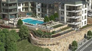 A multi-story residential building with a swimming pool, balconies, and a stone wall with text. - Landing | Modern 1BD, Gym, Clubhouse (Fort Worth)