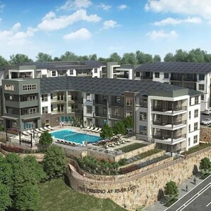 Ein mehrgeschossiges Wohnhaus mit Swimmingpool, Balkonen und einer Mauer aus Stein mit Schrift.