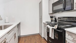 Cocina compacta con microondas, estufa y lavavajillas.