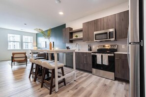A modern kitchen with a central island, stainless steel appliances, and a view of the city.