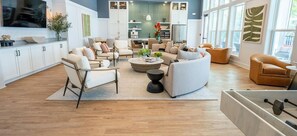 Ein modernes Wohnzimmer mit einer Couch, Sesseln, einem Couchtisch und einem Essbereich mit Stühlen und einem Tisch.