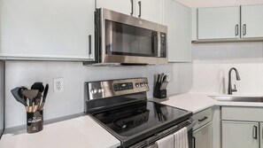 A modern kitchen with stainless steel appliances, a built-in oven, and a microwave. - Landing | Spectacular 2BD, Gym, Courtyard (Houston)