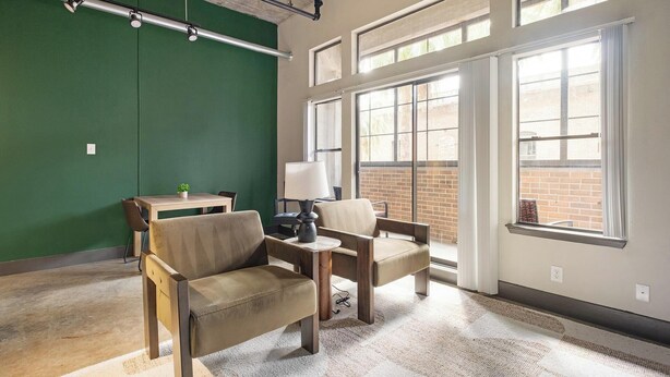 A room with two chairs, a small table, a lamp, and a green wall. - Landing | Beautiful 1BD, Gym, Courtyard (Houston)