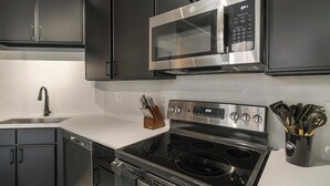 Eine moderne Küche mit Edelstahlgeräten, darunter eine Mikrowelle, ein Backofen und ein Geschirrspüler.