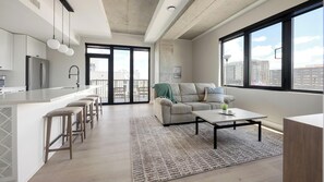 A modern apartment with a kitchen, dining area, and living room. - Landing | Beautiful 2BD, Yoga Studio, Gym (Denver)