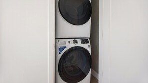 Ein platzsparender, wandmontierter Wasch- und Trockner-Apparat mit Bedienfeld und einem Hinweis auf 'SMARTER LAUNDRY' und 'ULTRAFRESH VENT SYSTEM'.