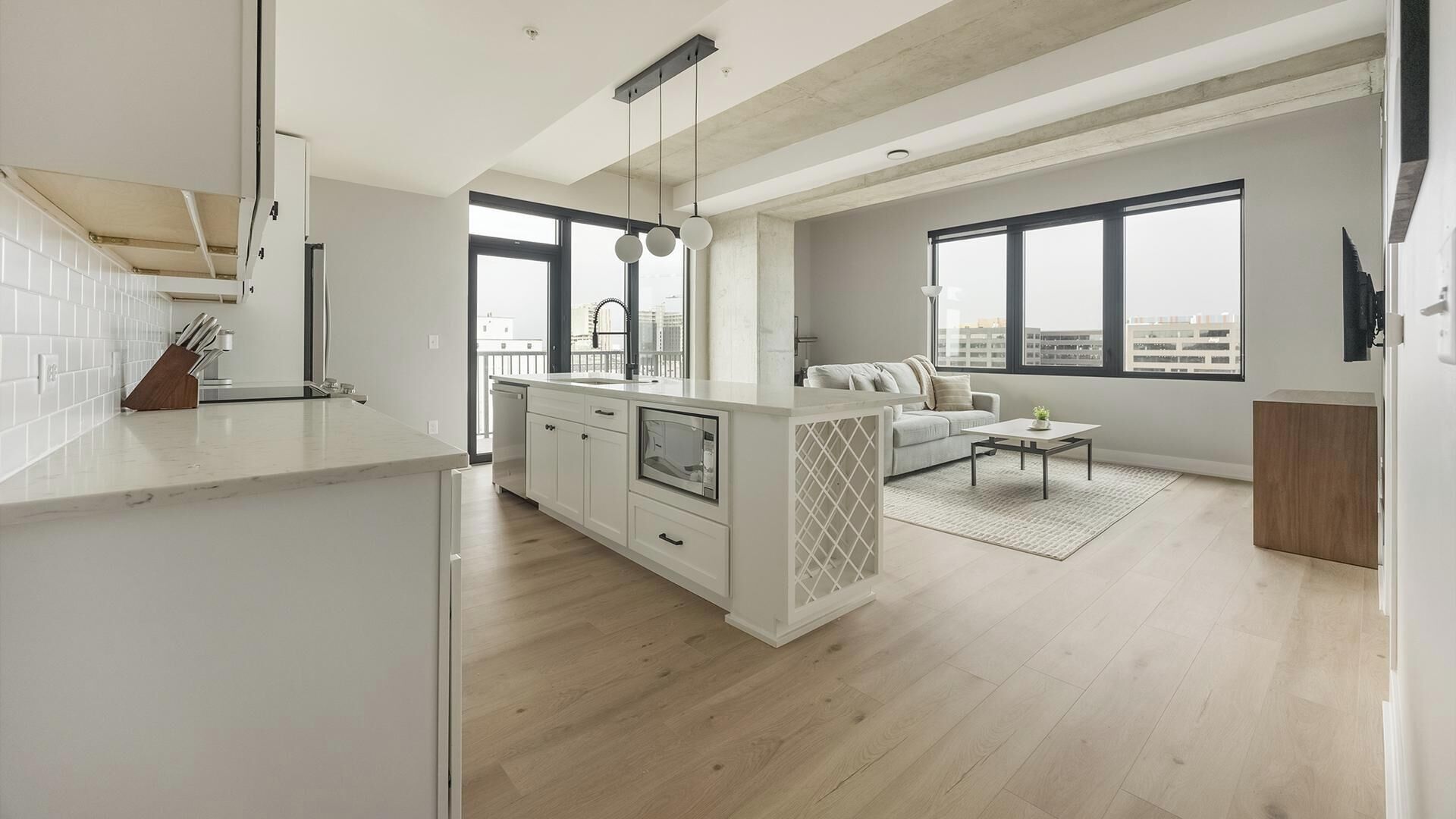 A modern apartment with a kitchen, living area, and large windows.