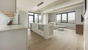 A modern apartment with a kitchen, living area, and large windows. - Landing | Amazing 2BD, Yoga Studio, Gym (Denver)