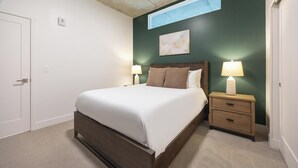 Un dormitorio con cama, mesitas de noche y una lámpara de pared.