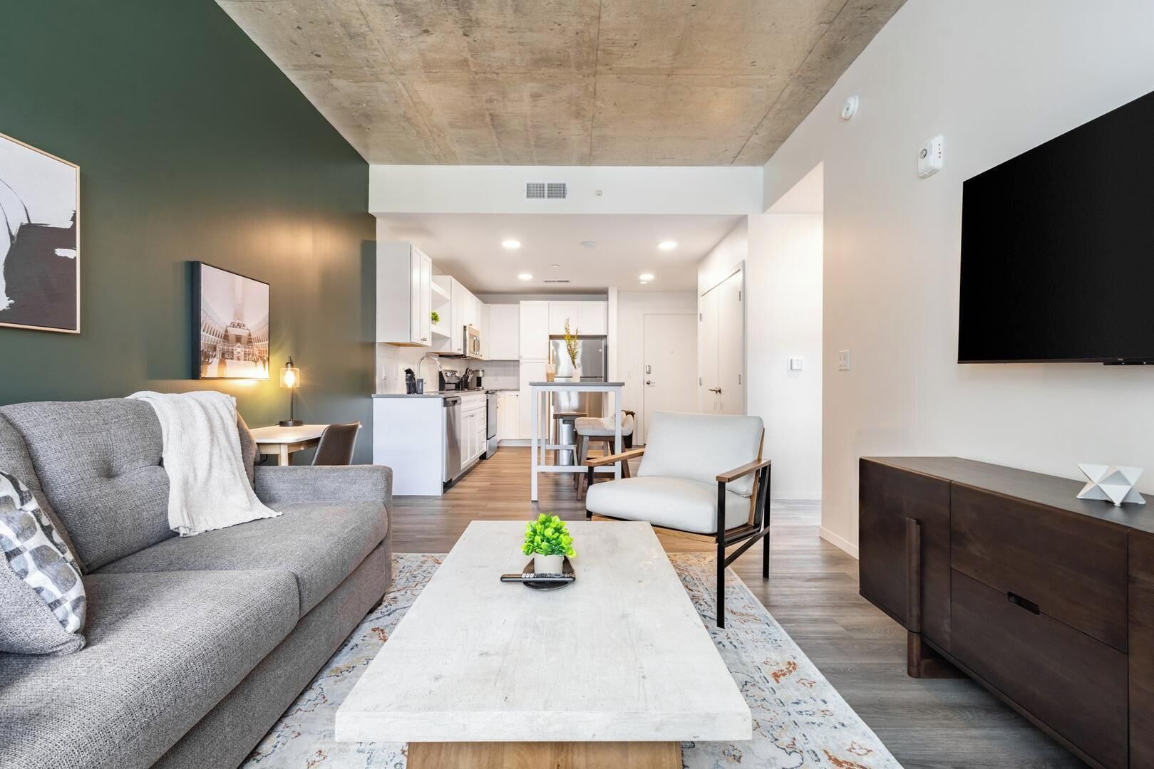 Un salon moderne avec un canapé, une table basse et un téléviseur fixé au mur.