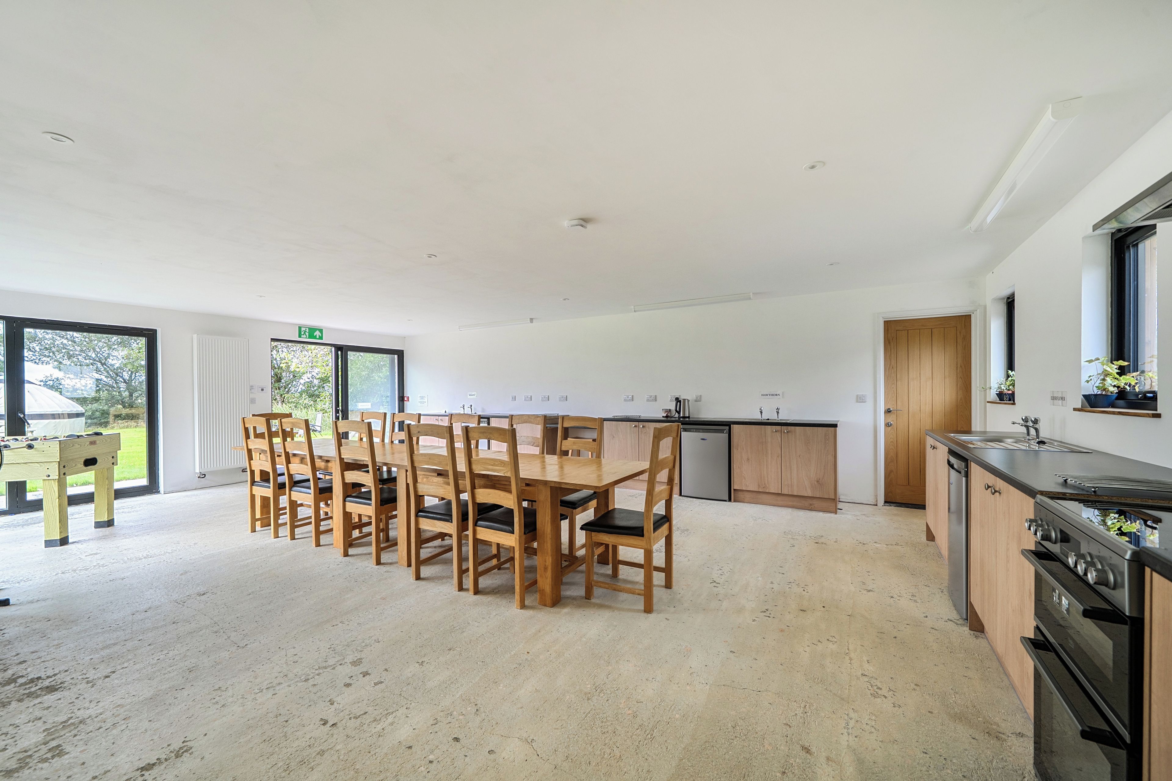 A spacious kitchen with wooden cabinets, a built-in oven, and a dining area with a wooden table and chairs.