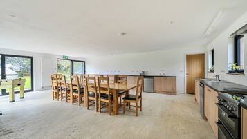 A spacious kitchen with wooden cabinets, a built-in oven, and a dining area with a wooden table and chairs.