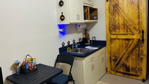 A compact kitchen with a sink, cabinets, and a wooden door. - Cozy 1-bedroom garage apartment in pleasant Hot Springs National Park, (Hot Springs)