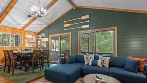 Ein gemütliches Blockhaus-Interieur mit einer Eckcouch, einem Esstisch und Stühlen.