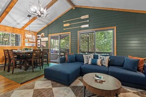 Ein gemütliches Blockhaus-Interieur mit einer Eckcouch, einem Esstisch und Stühlen.