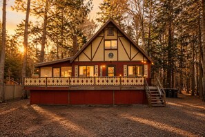 Eine Hütte mit Balkon, Schornstein und einer Uhr.
