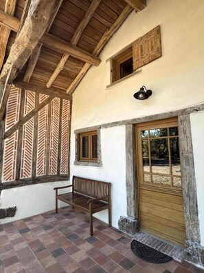 A rustic building with a wooden bench, a door, and a window. - La Landaise - COMMENSACQ (COMMENSACQ)