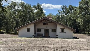 A single-story building with a pitched roof, a front porch, and a small front window. - La Landaise - COMMENSACQ (COMMENSACQ)