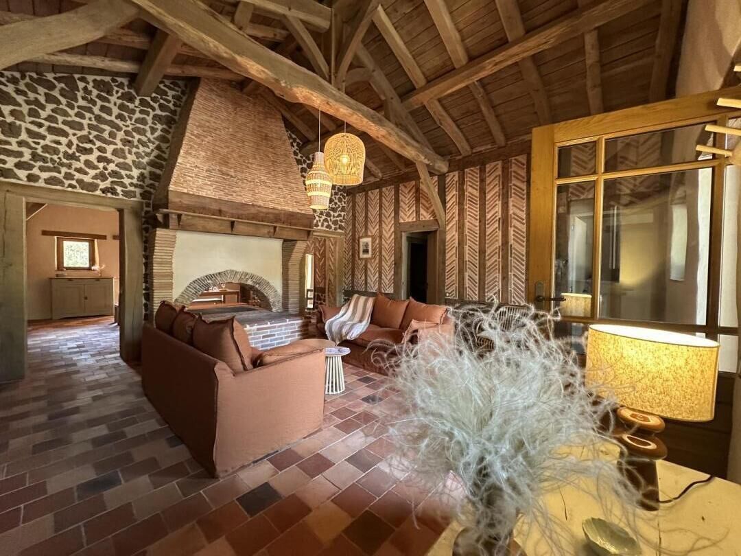 A cozy living room with a fireplace, a sofa, and a lamp.