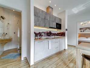 Eine moderne Küche mit Kochinsel, integrierten Geräten und Blick zum Wohnbereich.