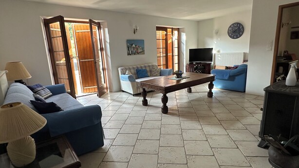 A living room with a sofa, a coffee table, a television, and a fireplace. - Farmhouse sleeps 12 - Pool, Table Tennis, Parking (St Andre de Lidon)