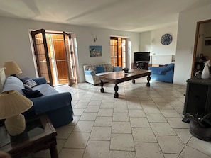 Un salon avec un canapé, une table basse, un téléviseur et une cheminée.