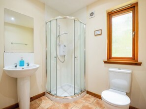 Ein Badezimmer mit Duschkabine, weißem Waschbecken und Toilette.