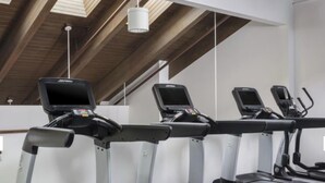 Ett gym med löpband, motionscyklar och en roddmaskin.