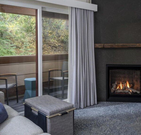A cozy room with a fireplace, a sofa, and a table with chairs. - Cozy vacation get a way located in serene Vail.  Skiing and hiking. Sleeps 10 (Vail)