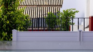 Une piscine dotée d’un toit carrelé et d’une balustrade blanche, visible au premier plan.