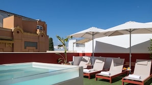 Zona de piscina al terrat amb gandules i para-sols.