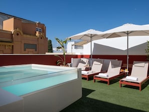 A rooftop pool area with lounge chairs and umbrellas. - Hommyhome San Esteban 101 (Sevilla)
