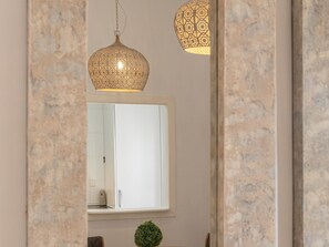 A room with a large mirror, a hanging lamp, and a small green plant. - Hommyhome San Esteban 101 (Sevilla)