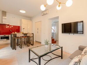 A modern living room with a glass coffee table, a flat-screen TV mounted on the wall, and a sofa. - Hommyhome San Esteban 102 (Sevilla)