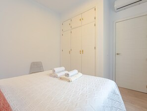 Ein Schlafzimmer mit Bett, Kleiderschrank und Tür.