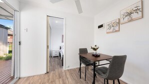 Un'area pranzo moderna con tavolo, sedie e una ventola a soffitto.
