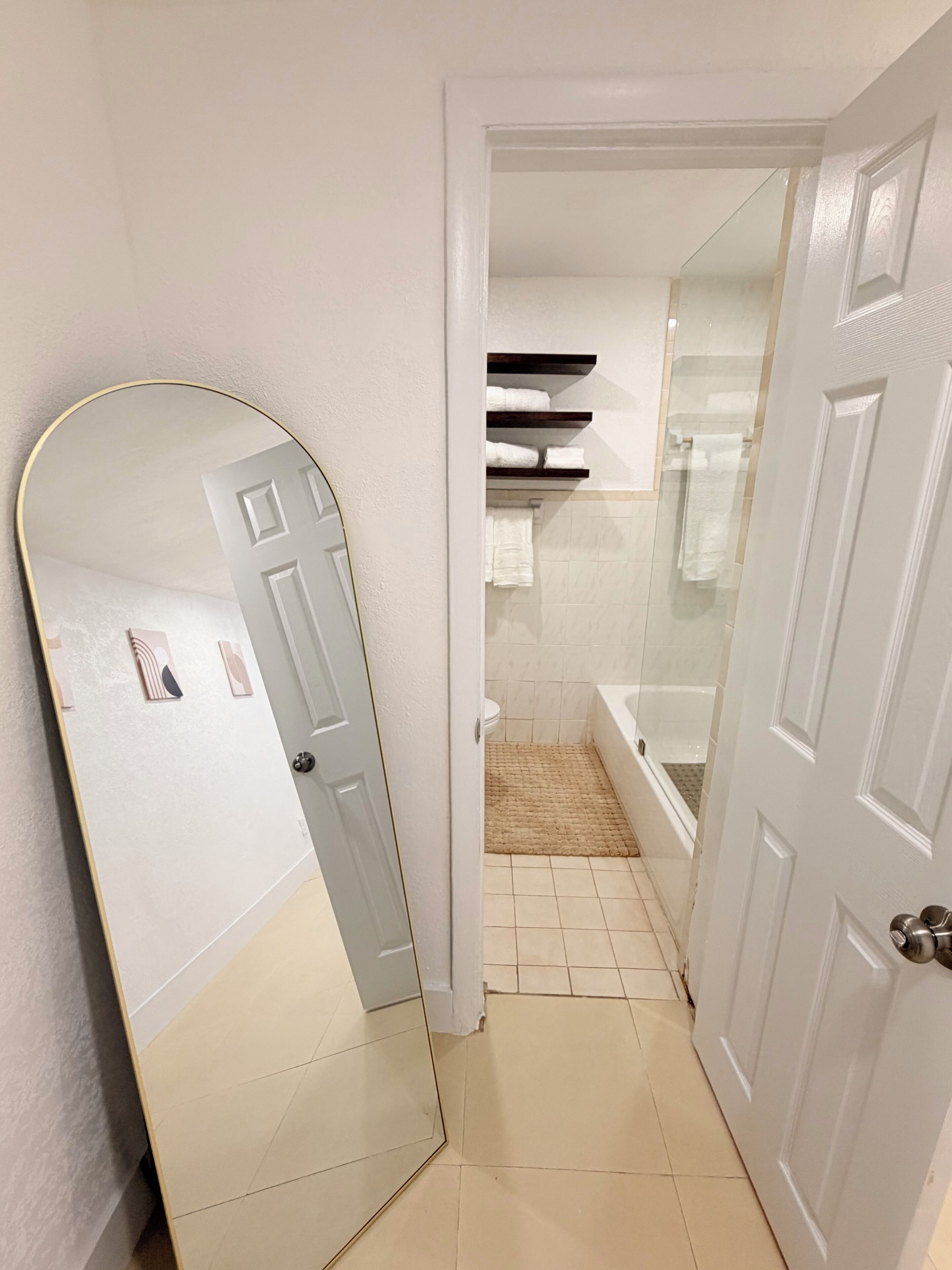A bathroom with a toilet, a bathtub, and a shower area.