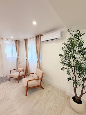 A room with two beige armchairs, a potted plant, and an air conditioning unit on the wall. - Entire house in the Brickell area just 5 minutes from downtown Miami (Miami)