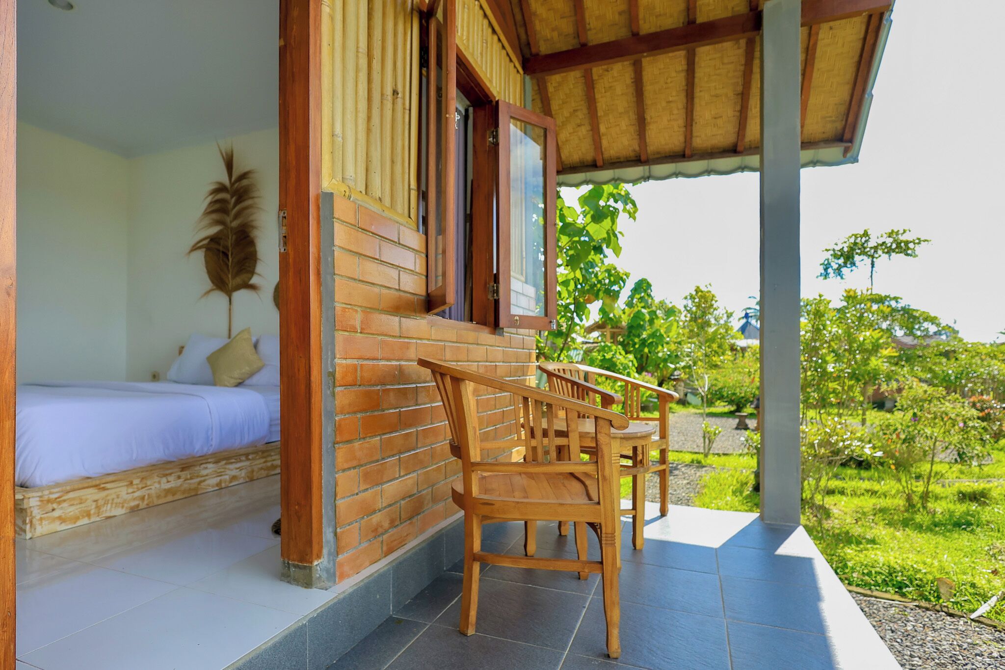 A wooden-framed room with a bed, a window, and a view of greenery.