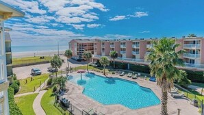 Un hotel con piscina, vista sulla spiaggia e un edificio a più piani.